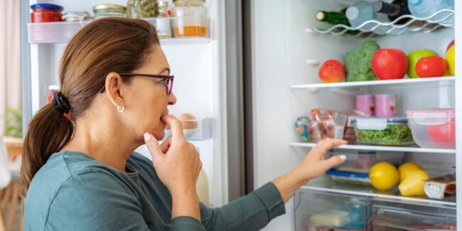 woman looking in fridge wondering what to make
